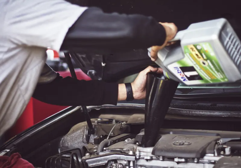 Fresh motor oil being poured into an engine
